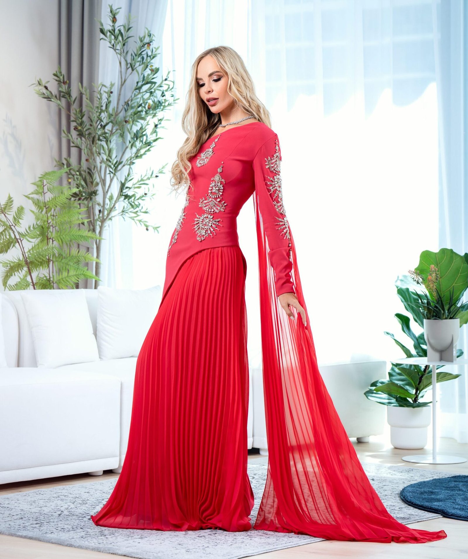 Red1 Model wearing a red couture gown with crystal-embellished bodice, pleated skirt, and sheer sleeve panels – Casa Reina Couture