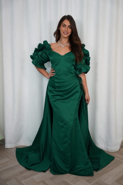 Model wearing an emerald green evening gown with sweetheart neckline, puff sleeves, draped skirt, and flowing train – Casa Reina Boutique