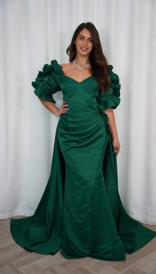 Model wearing an emerald green evening gown with sweetheart neckline, puff sleeves, draped skirt, and flowing train – Casa Reina Boutique