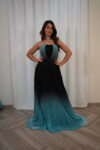Model wearing a strapless teal-to-black ombre pleated evening gown with sequin-detailed bodice – Casa Reina Boutique