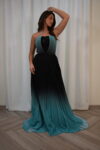 Model wearing a strapless teal-to-black ombre pleated evening gown with sequin-detailed bodice – Casa Reina Boutique