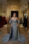 Model wearing an embellished halter evening gown with detachable satin cape in Ice Blue – Casa Reina Boutique