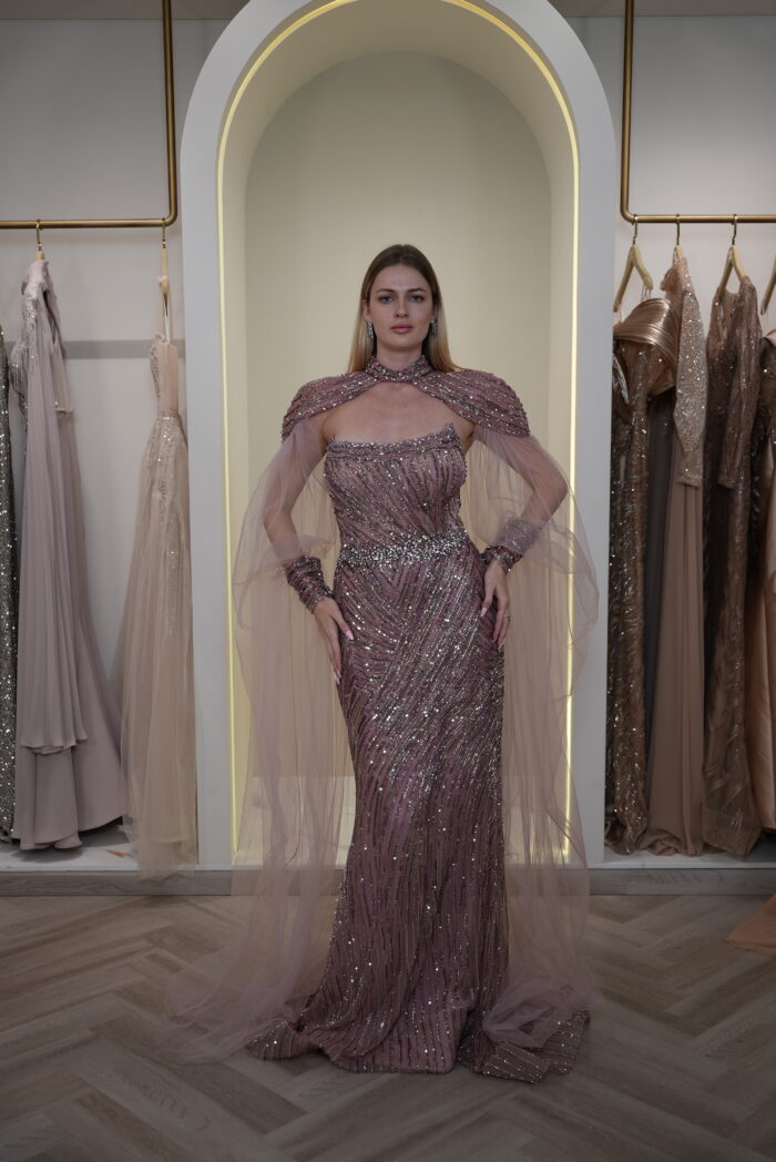 Model wearing a plum evening gown with sequins, strapless bodice, and dramatic draped crystal-beaded cape – Casa Reina Boutique