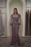 Model wearing a plum evening gown with sequins, strapless bodice, and dramatic draped crystal-beaded cape – Casa Reina Boutique