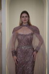 Model wearing a plum evening gown with sequins, strapless bodice, and dramatic draped crystal-beaded cape – Casa Reina Boutique
