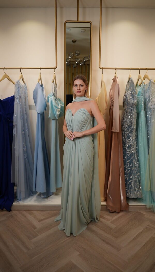 Model wearing a mint green strapless chiffon gown with sweetheart neckline, draped skirt, and detachable scarf detail – Casa Reina Boutique