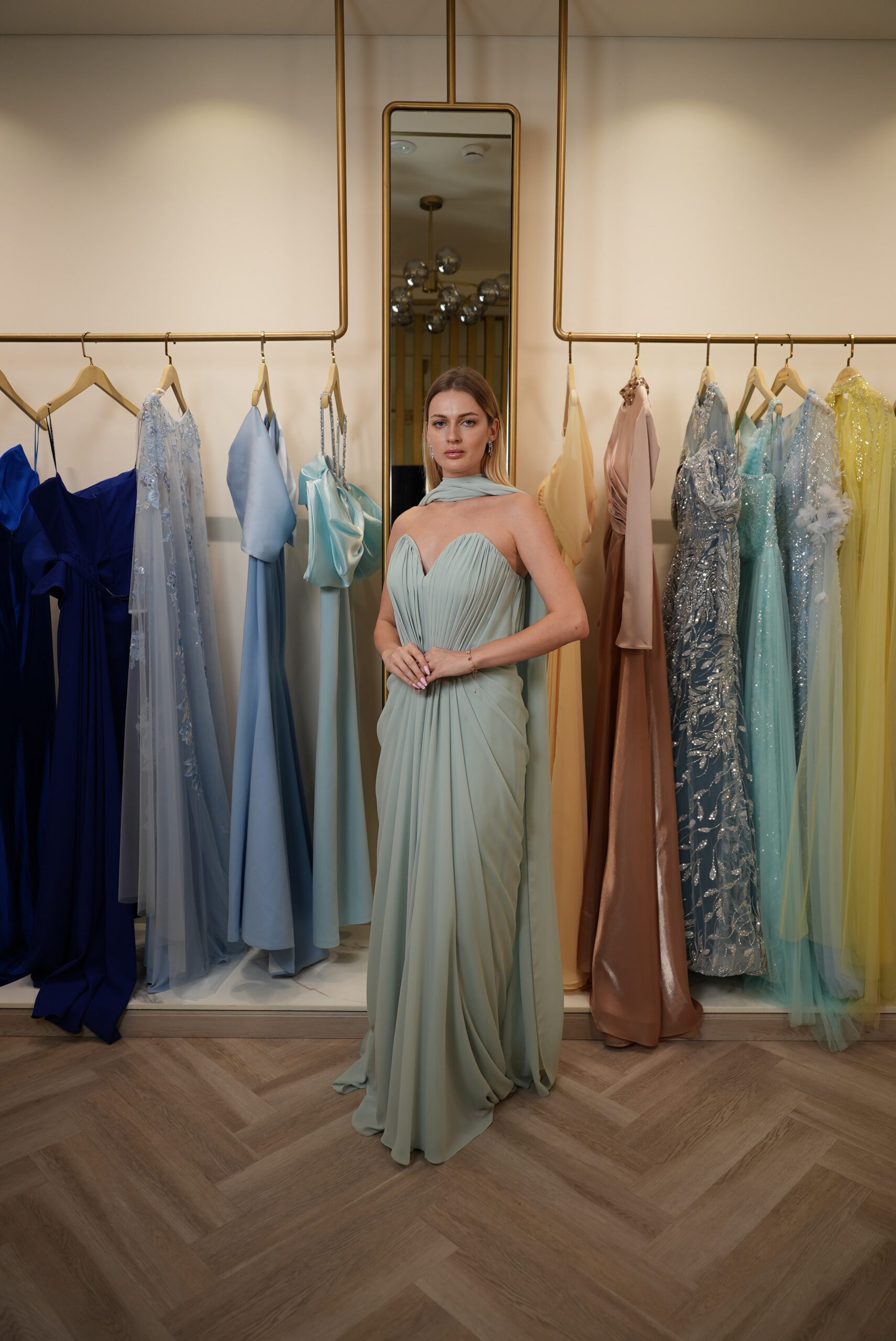 Model wearing a mint green strapless chiffon gown with sweetheart neckline, draped skirt, and detachable scarf detail – Casa Reina Boutique