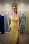 Model wearing a vibrant yellow sweetheart evening gown with ruched bodice, draped detailing, and thigh-high slit – Casa Reina Boutique