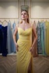 Model wearing a vibrant yellow sweetheart evening gown with ruched bodice, draped detailing, and thigh-high slit – Casa Reina Boutique