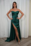 Model wearing a strapless satin corset evening gown with draped bodice and thigh-high slit, available in emerald green – Casa Reina couture collection.