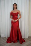 Model wearing an embellished strapless satin evening gown with embroidered corset bodice and thigh-high slit, available in crimson red – Casa Reina couture collection.