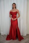 Model wearing an embellished strapless satin evening gown with embroidered corset bodice and thigh-high slit, available in crimson red – Casa Reina couture collection.