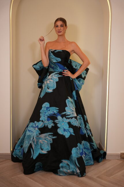 Model wearing a strapless black ball gown with oversized blue floral print and voluminous skirt – Casa Reina Boutique