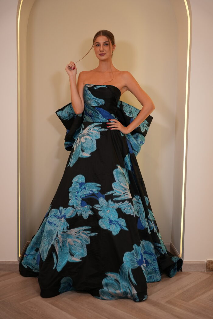 Model wearing a strapless black ball gown with oversized blue floral print and voluminous skirt – Casa Reina Boutique