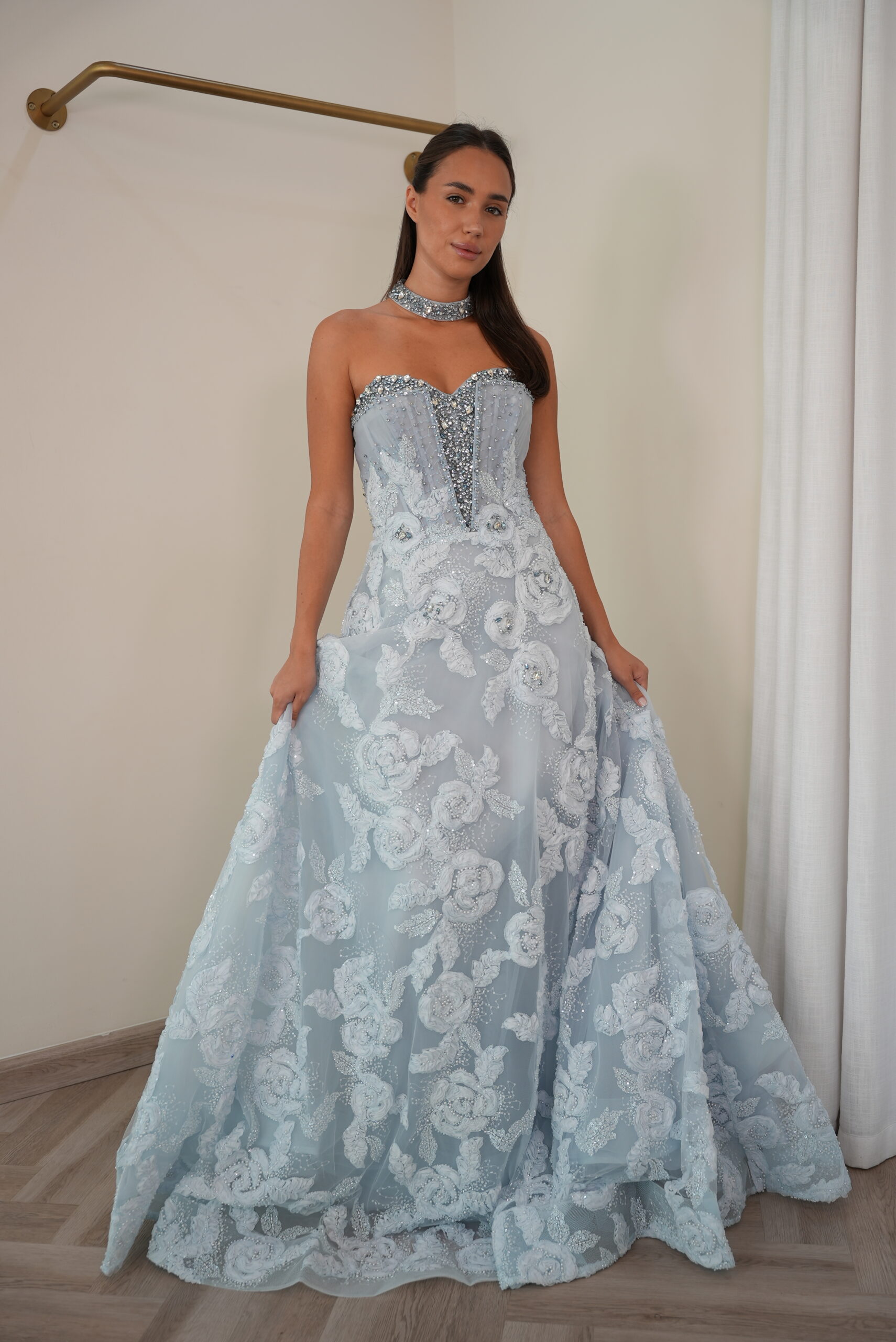 Model wearing an ice blue strapless evening gown with crystal-encrusted bodice, floral lace embroidery, and matching choker – Casa Reina Boutique