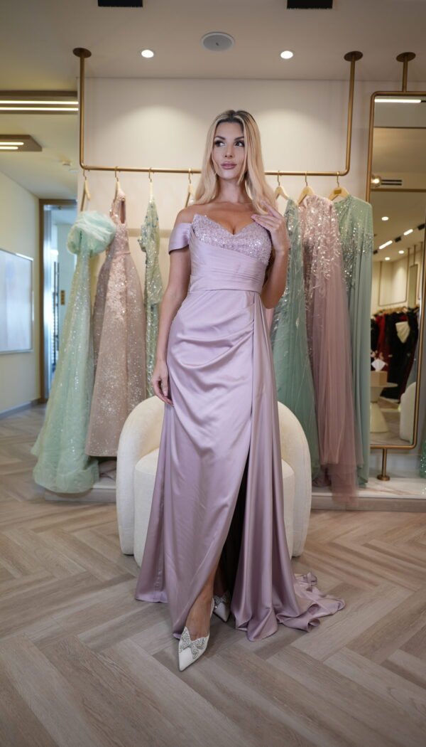 Model wearing a lilac satin off-shoulder evening gown with beaded sweetheart bodice, draped waist, and slit skirt – Casa Reina Boutique