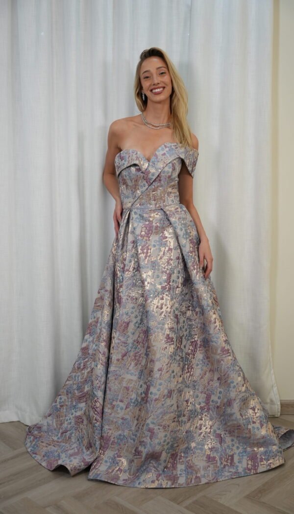 Model wearing a metallic brocade off-shoulder ball gown in silver, lilac, and blush tones with structured bodice and voluminous skirt – Casa Reina Boutique