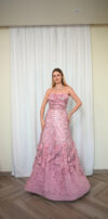 Model wearing a strapless ball gown with rosette detailing, sequin embroidery, and textured layered skirt in Rose Pink – Casa Reina Boutique