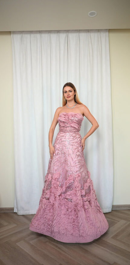 Model wearing a strapless ball gown with rosette detailing, sequin embroidery, and textured layered skirt in Rose Pink – Casa Reina Boutique