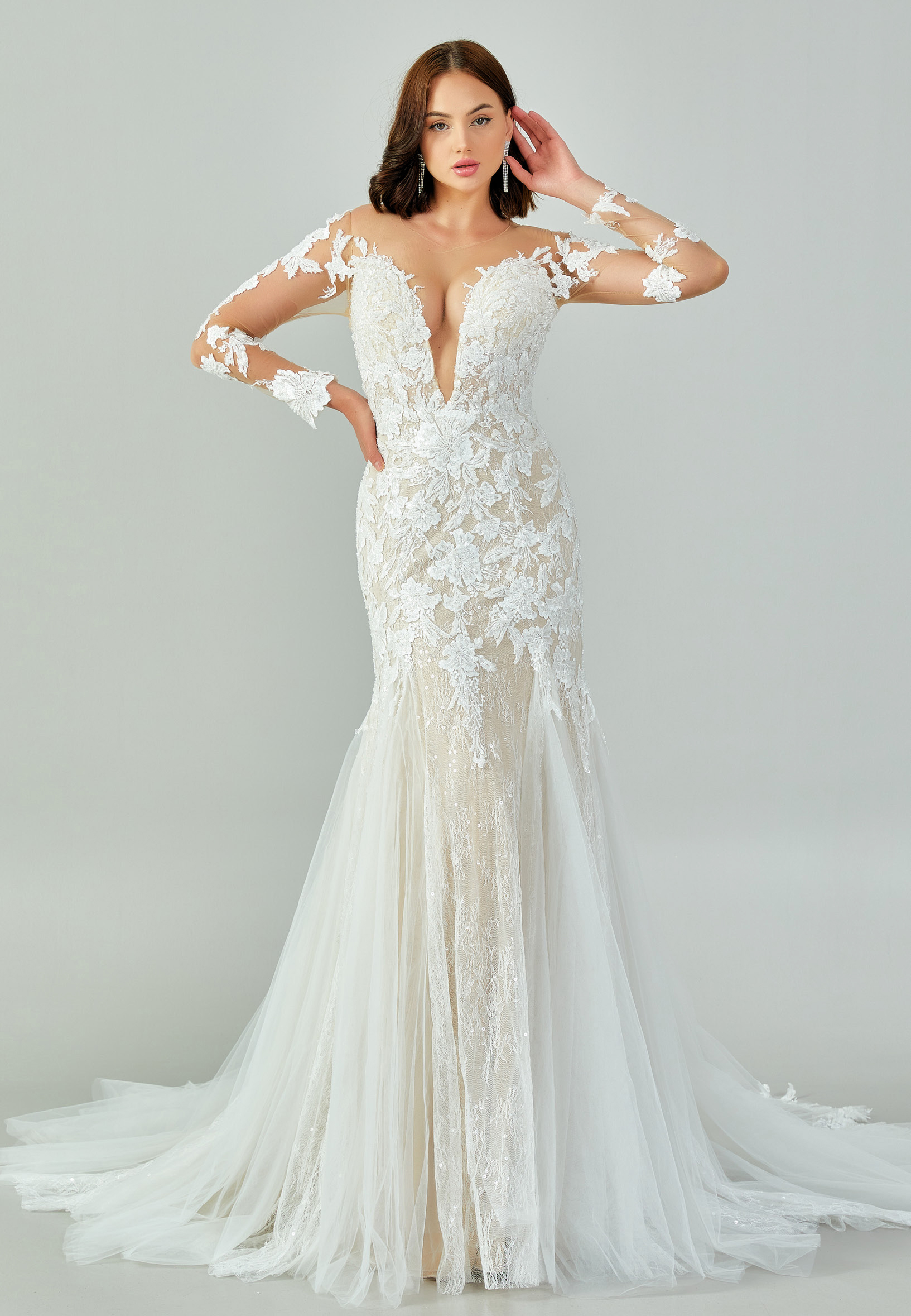 Bride wearing a regal long-sleeved ball gown with beaded embroidered bodice and illusion neckline from Casa Reina Bridal Collection
