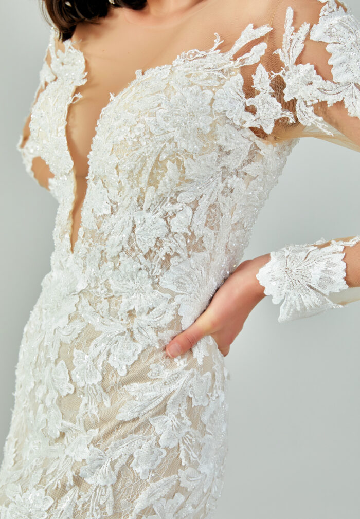 Bride wearing a regal long-sleeved ball gown with beaded embroidered bodice and illusion neckline from Casa Reina Bridal Collection