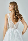 Bride wearing an ivory illusion lace and tulle A-line gown with deep V neckline and chapel train from Casa Reina Bridal Collection