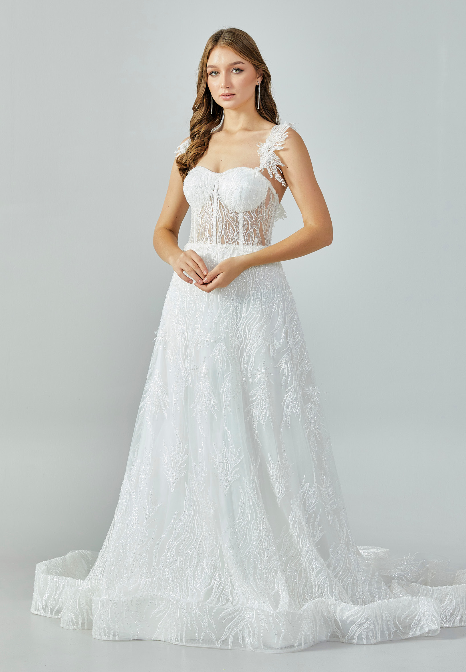 Bride wearing an illusion corset gown with leaf-lace embroidery and flowing tulle skirt from Casa Reina Bridal Collection