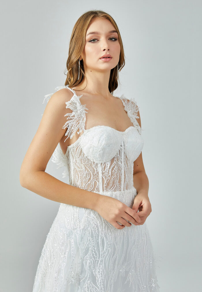 Bride wearing an illusion corset gown with leaf-lace embroidery and flowing tulle skirt from Casa Reina Bridal Collection