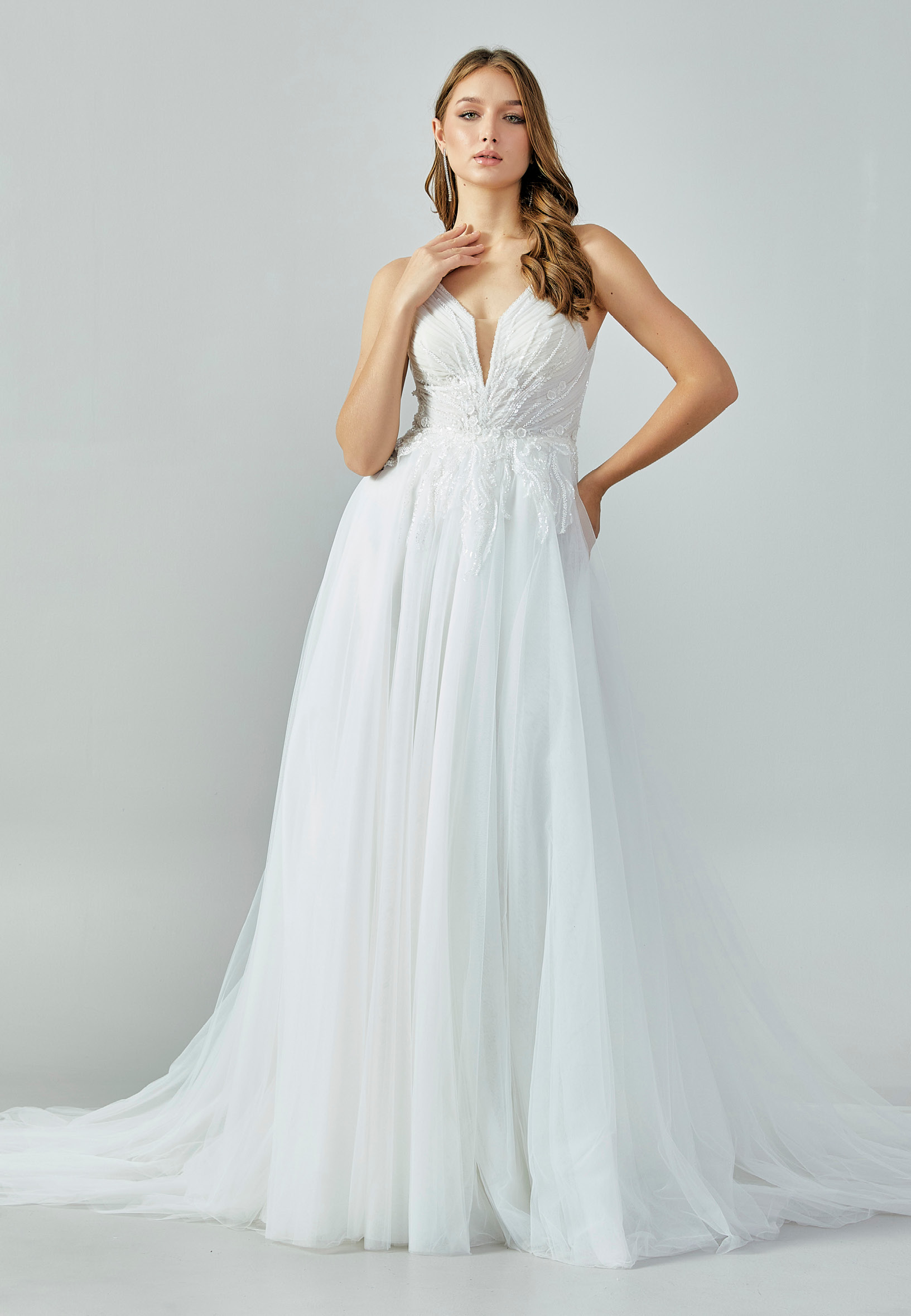 Bride wearing a soft tulle A-line gown with plunging illusion neckline and embroidered bodice from Casa Reina Bridal Collection