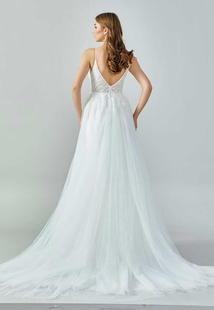 Bride wearing a soft tulle A-line gown with plunging illusion neckline and embroidered bodice from Casa Reina Bridal Collection