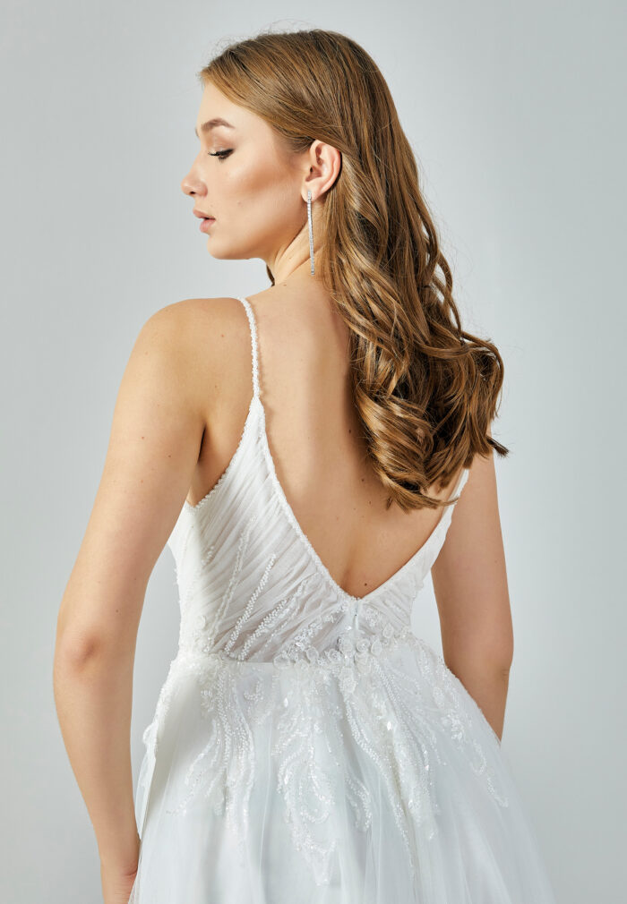 Bride wearing a soft tulle A-line gown with plunging illusion neckline and embroidered bodice from Casa Reina Bridal Collection