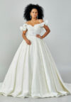 Bride wearing a ruffled off-shoulder ball gown with beaded corset bodice and embroidered jacquard skirt from Casa Reina Bridal Collection