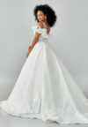 Bride wearing a ruffled off-shoulder ball gown with beaded corset bodice and embroidered jacquard skirt from Casa Reina Bridal Collection