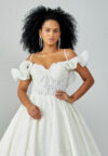 Bride wearing a ruffled off-shoulder ball gown with beaded corset bodice and embroidered jacquard skirt from Casa Reina Bridal Collection