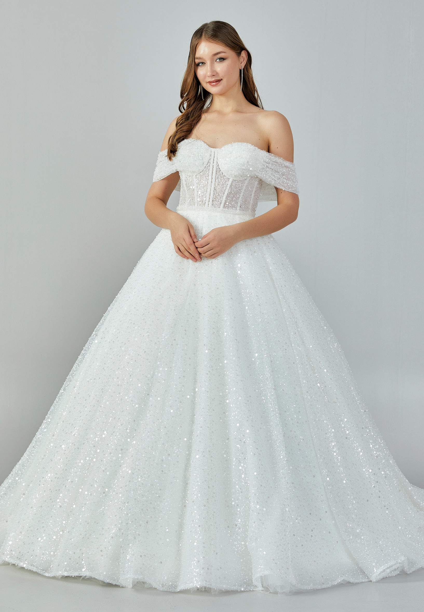 Bride wearing a crystal-embellished off-shoulder corset ball gown with glittering tulle skirt from Casa Reina Bridal Collection