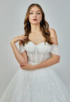 Bride wearing a crystal-embellished off-shoulder corset ball gown with glittering tulle skirt from Casa Reina Bridal Collection