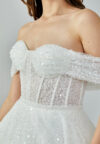 Bride wearing a crystal-embellished off-shoulder corset ball gown with glittering tulle skirt from Casa Reina Bridal Collection
