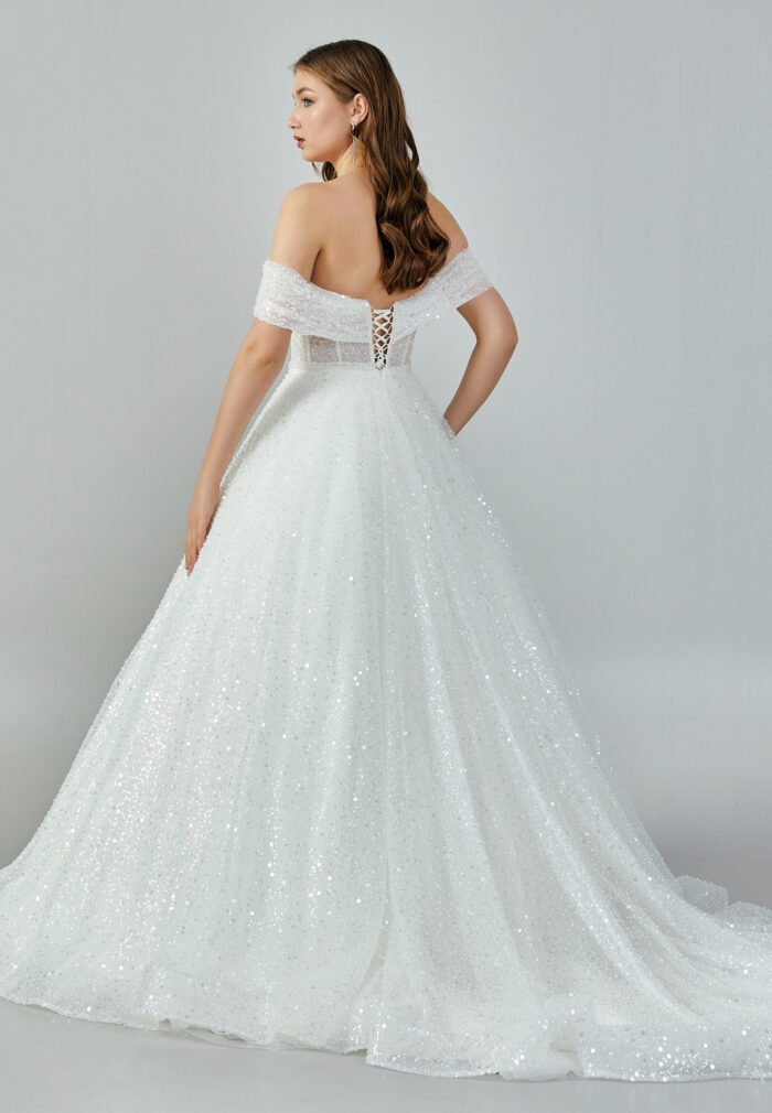 Bride wearing a crystal-embellished off-shoulder corset ball gown with glittering tulle skirt from Casa Reina Bridal Collection
