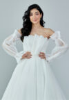 Bride wearing an off-shoulder sculpted organza ball gown with voluminous sleeves and pleated bodice from Casa Reina Bridal Collection