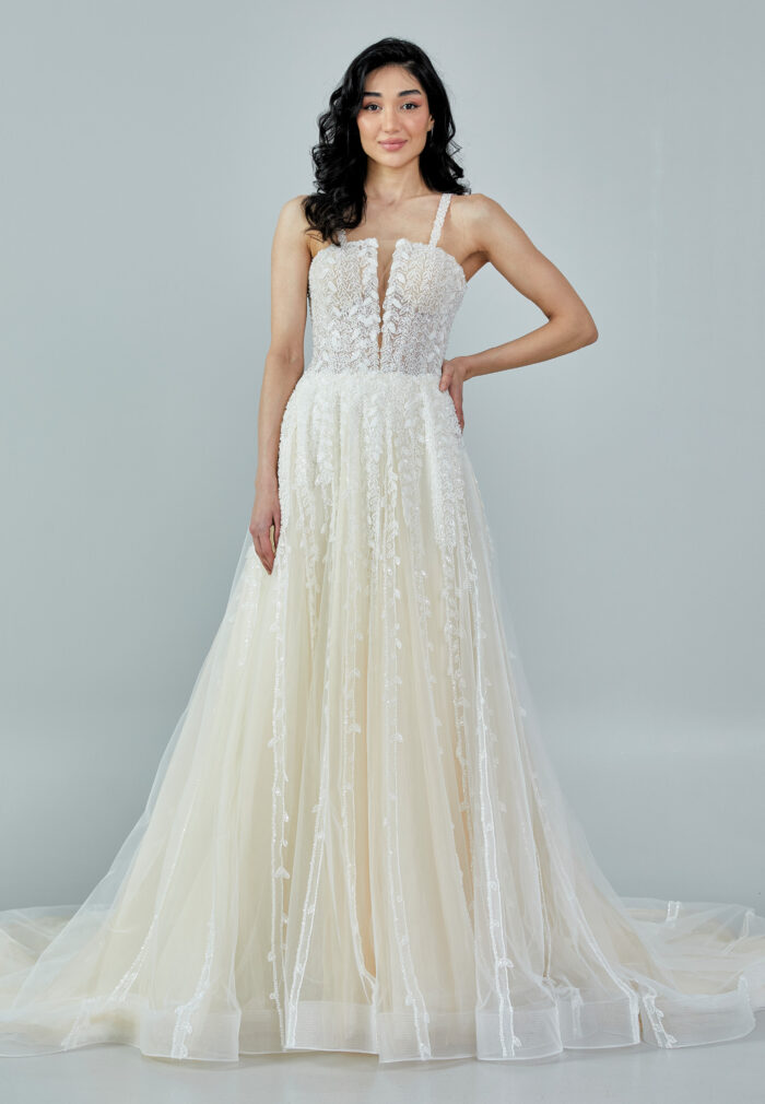 Bride wearing a romantic lace and tulle gown with deep illusion neckline and flowing A-line skirt from Casa Reina Bridal Collection