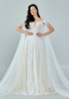 Bride wearing an ethereal tulle gown with illusion bodice, lace embroidery, and flowing cape sleeves from Casa Reina Bridal Collection