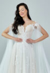 Bride wearing an ethereal tulle gown with illusion bodice, lace embroidery, and flowing cape sleeves from Casa Reina Bridal Collection
