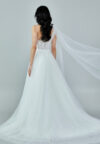 Bride wearing a one-shoulder corseted gown with draped tulle and thigh-high slit from Casa Reina Bridal Collection