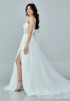 Bride wearing a one-shoulder corseted gown with draped tulle and thigh-high slit from Casa Reina Bridal Collection