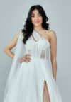 Bride wearing a one-shoulder corseted gown with draped tulle and thigh-high slit from Casa Reina Bridal Collection