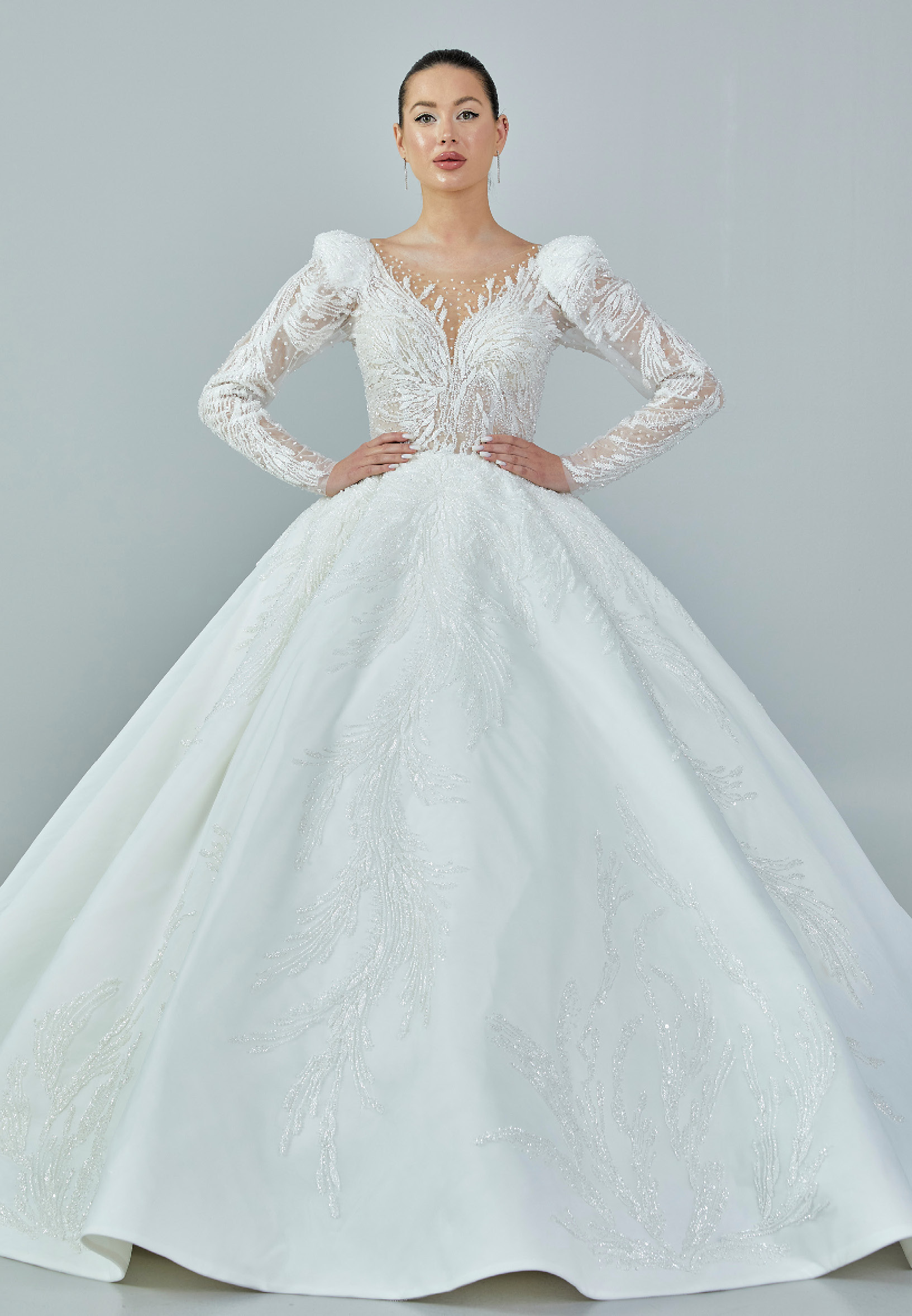 Bride wearing a regal embroidered ballgown with illusion long sleeves and crystal bead detailing from Casa Reina Bridal Collection