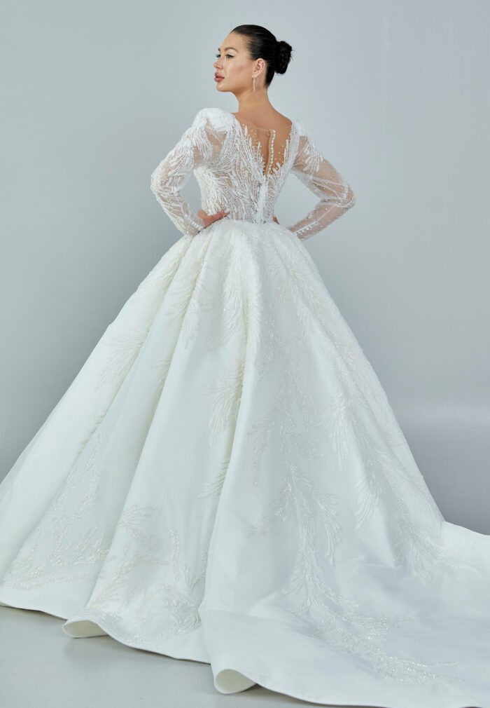 Bride wearing a regal embroidered ballgown with illusion long sleeves and crystal bead detailing from Casa Reina Bridal Collection