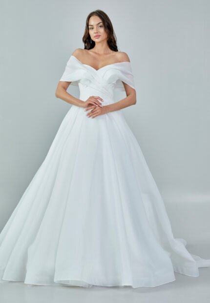 Bride wearing an off-shoulder organza ball gown with draped bodice and full skirt from Casa Reina Bridal Collection