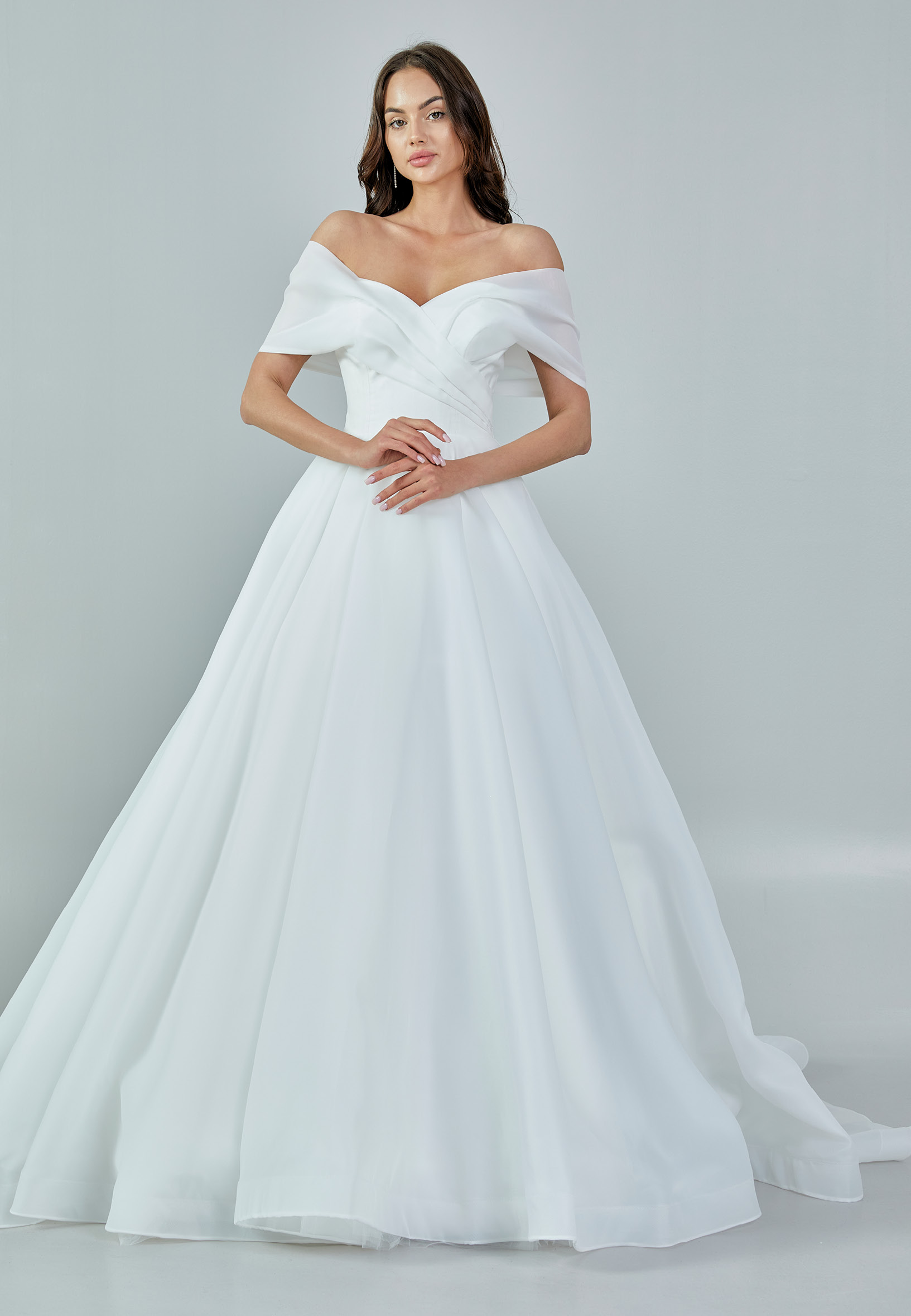 Bride wearing an off-shoulder organza ball gown with draped bodice and full skirt from Casa Reina Bridal Collection