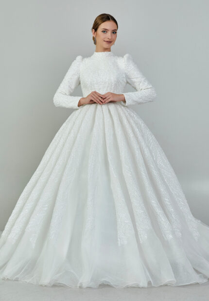 Bride wearing a high-neck long sleeve ball gown with hand-beaded detailing and cathedral train from Casa Reina Bridal Collection